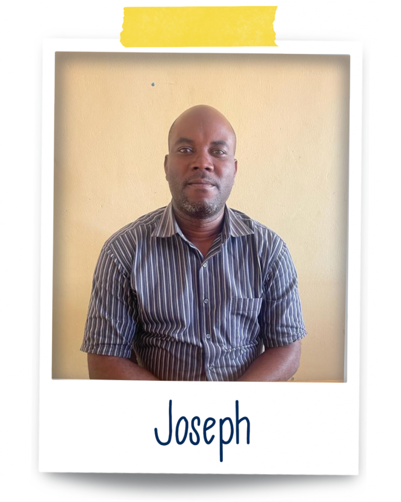 Joseph, a Ugandan man sitting on a chair wearing a striped shirt with a slight smile on his face, is looking at the camera.