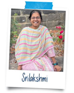 Srilakshmi, a 34 year old woman with brown skin and black hair. She’s wearing glasses the same colour as her hair and a pink salwar.